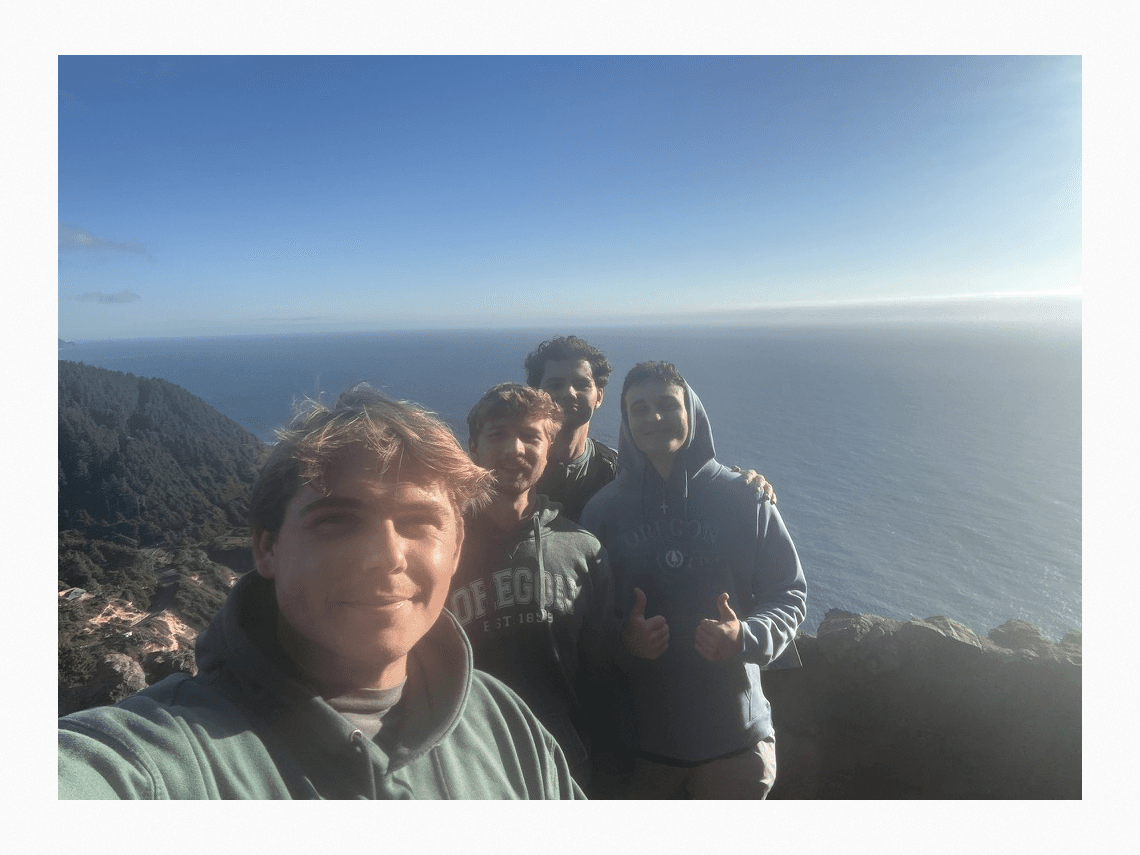 Luke and three friends overlooking the ocean from a coastal overlook