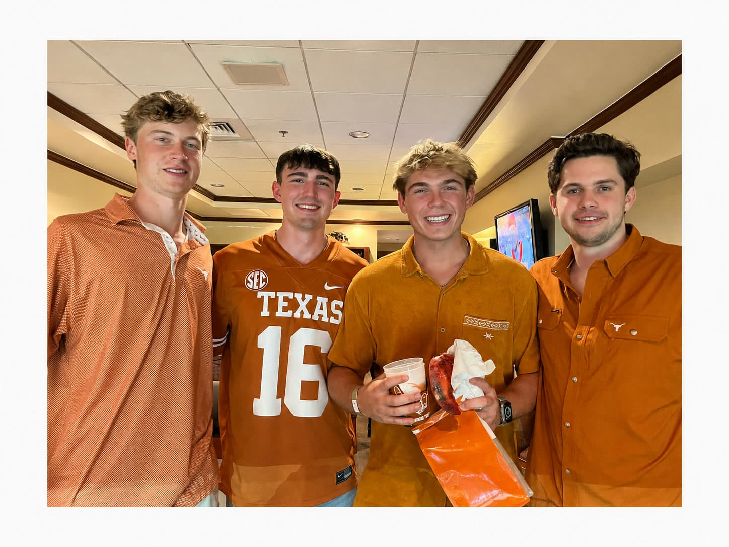 Luke and three friends in burnt orange at a Texas Longhorns game
