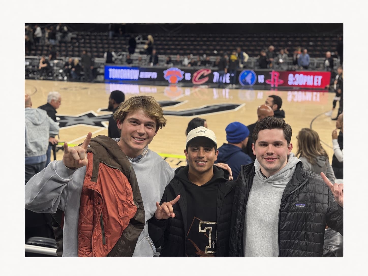 Luke and two friends watching the Spurs play in Moody Center